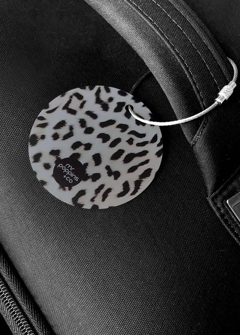 Metal luggage tag in cheetah print on a black suitcase
