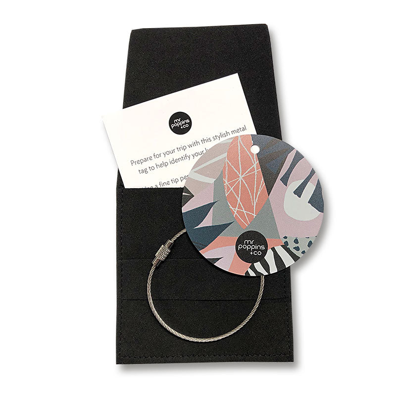 Metal luggage tag in pink dusk print on a black gifting envelope