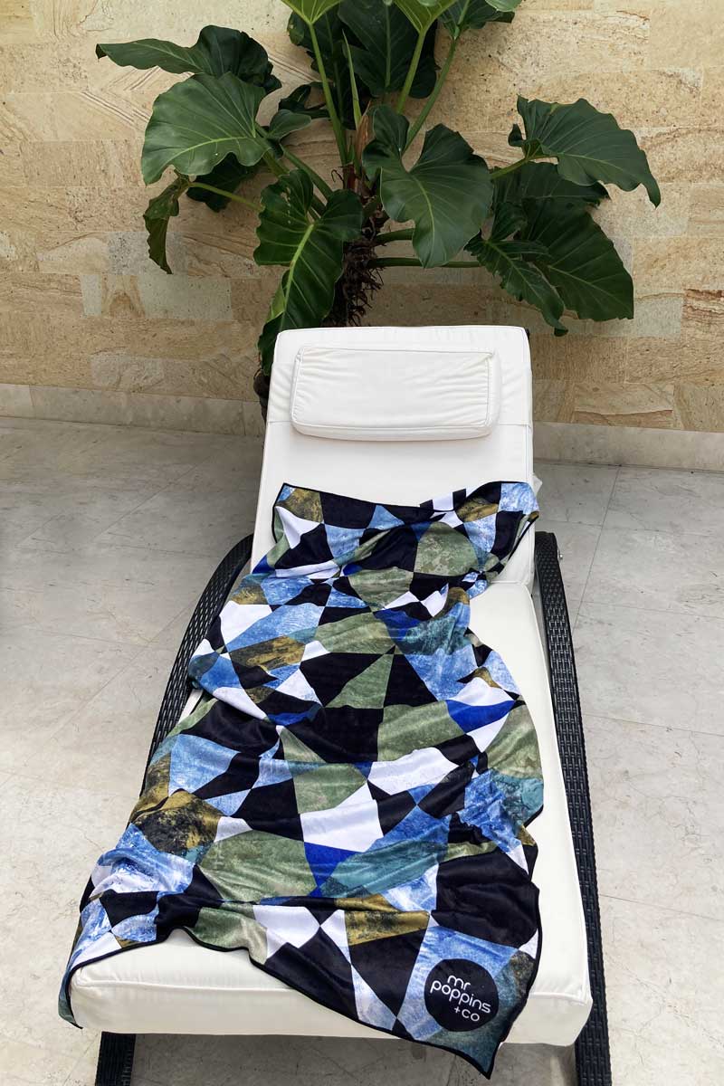 Men&#39;s geometric towel on a pool side deckchair