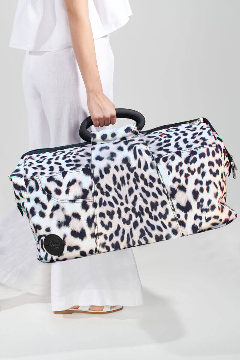 cheetah print travel bag in woman&#39;s hand