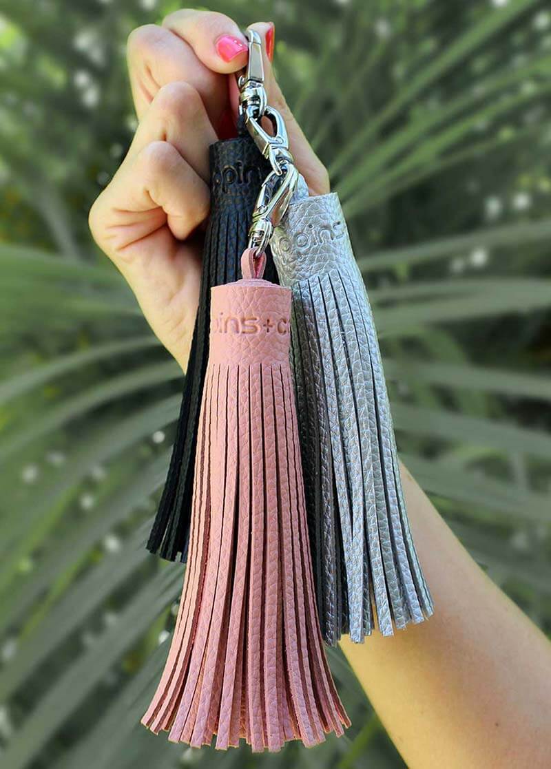 Premium chunky bag tassels in pink silver and black hanging on hand for scale