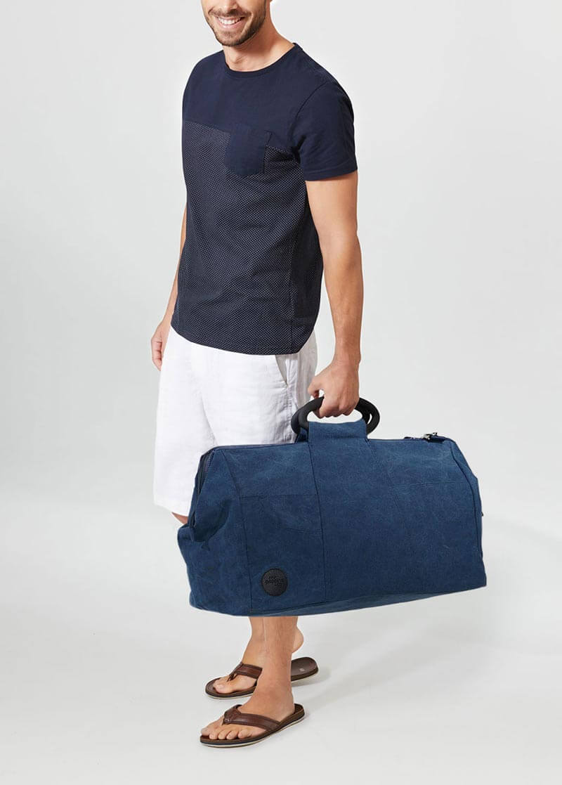 man holding denim weekender